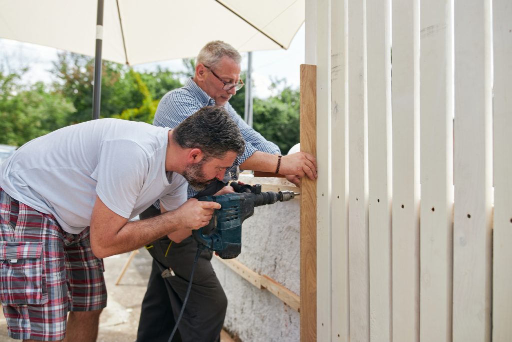 Men installing fence together installing a fence